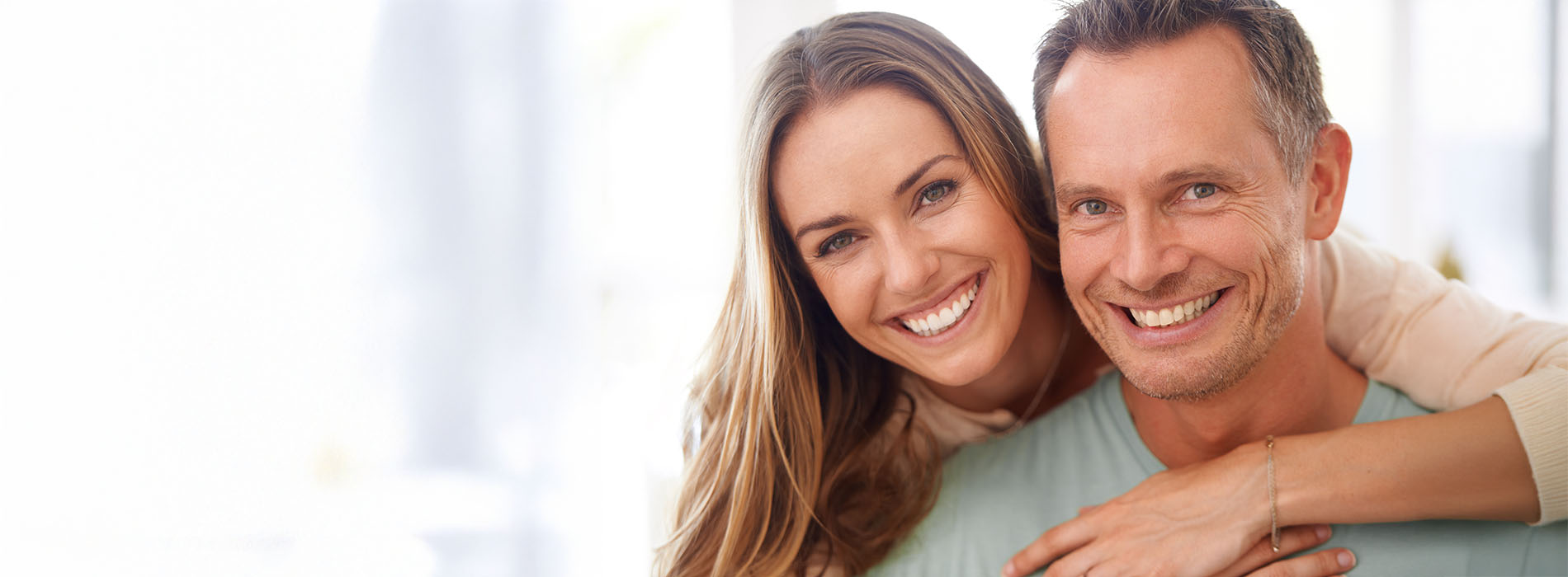 The image shows a man and woman embracing, with a warm, happy expression on their faces, suggesting a close relationship between them.