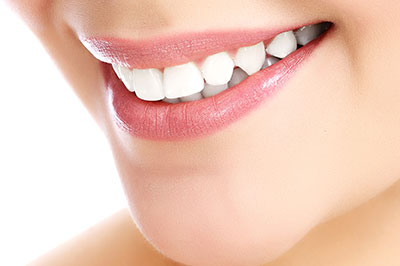 The image features a close-up view of a person s face with a focus on their smile, showcasing teeth whitening results.