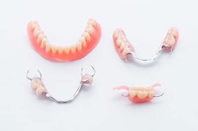 Alt text   A photograph of two pairs of dentures displayed side by side on a white background, with one pair featuring a large set of teeth and the other a smaller set.