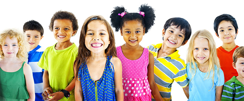 The image shows a group of children of various ages and ethnicities posing for a photo with smiles on their faces, wearing casual clothing.